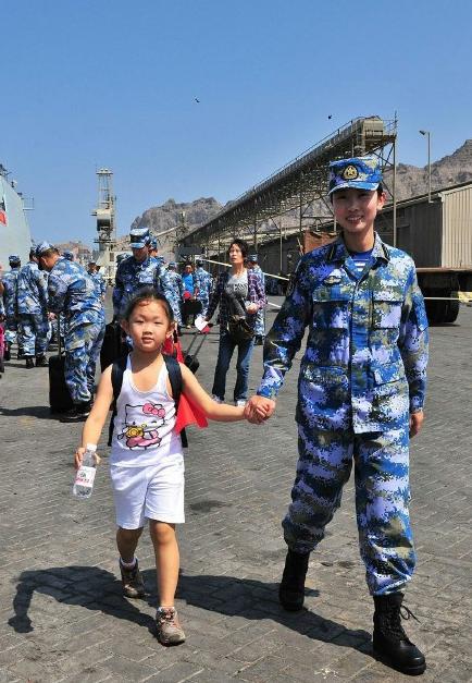 2015年3月，也門，海軍女戰士牽著一名小女孩的手準備登上軍艦。